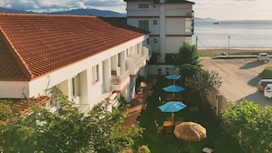 A hotel with a red-tiled roof, a balcony, and a view of the sea. - Hotel Rodeiramar (Cangas)