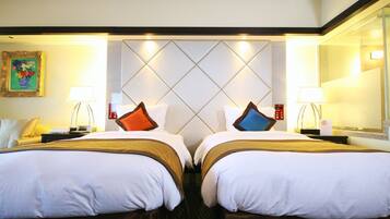 A hotel room with two beds, a large mirror, and a decorative wall panel.