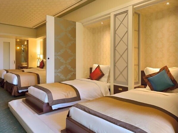 A hotel room with three beds, each with a brown headboard, white bedding, and decorative pillows. - Okinawa Kariyushi Resort Exes Onna (Onna)