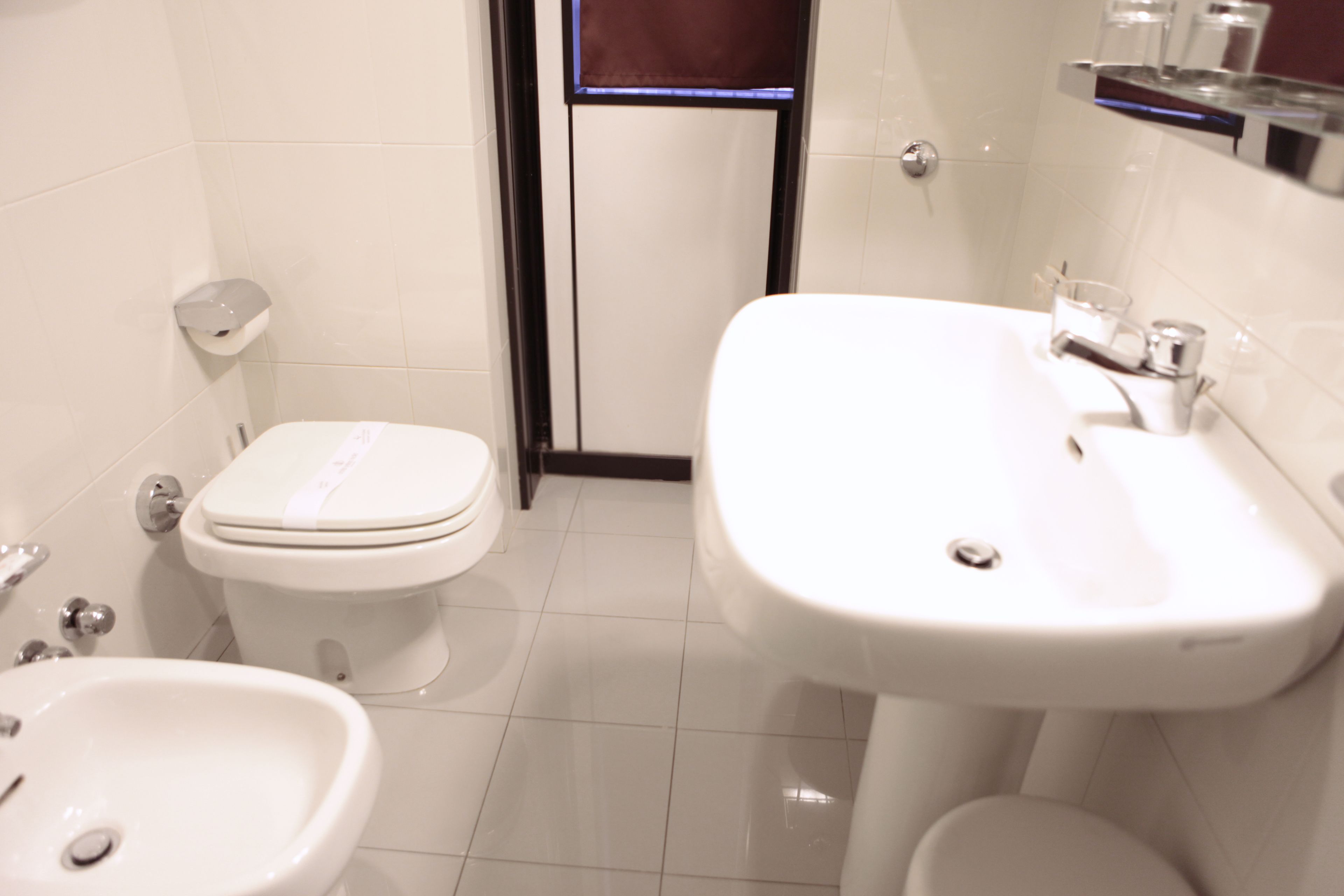 A bathroom with a toilet, bidet, and sink.