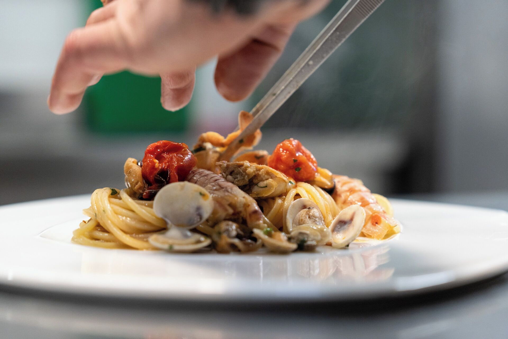 A plate of pasta with clams and cherry tomatoes.