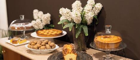 A dessert display with various cakes and pastries, including a Crostata, a Cianella, and a Cianella with yogurt and vanilla.