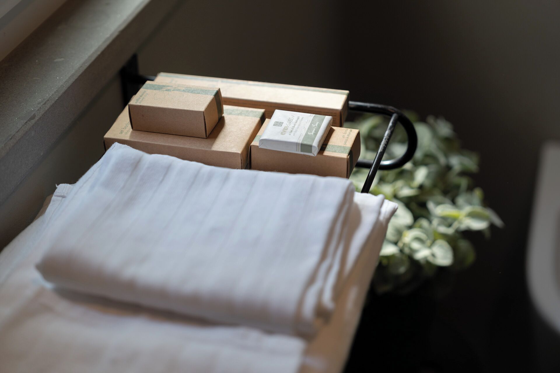 A window sill with several cardboard boxes and a white cloth.