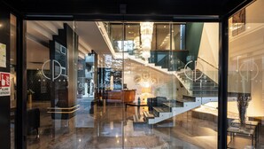 A modern hotel lobby with a glass entrance, a staircase, and a reception desk. - Cristal Palace Hotel (Andria)