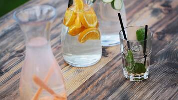Three glass containers with drinks on a wooden table.