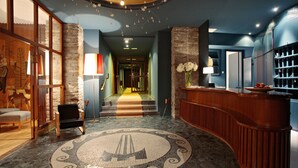 A lobby with a reception desk, a patterned floor, and a staircase leading to another area. - Miramonte (Bad Gastein)