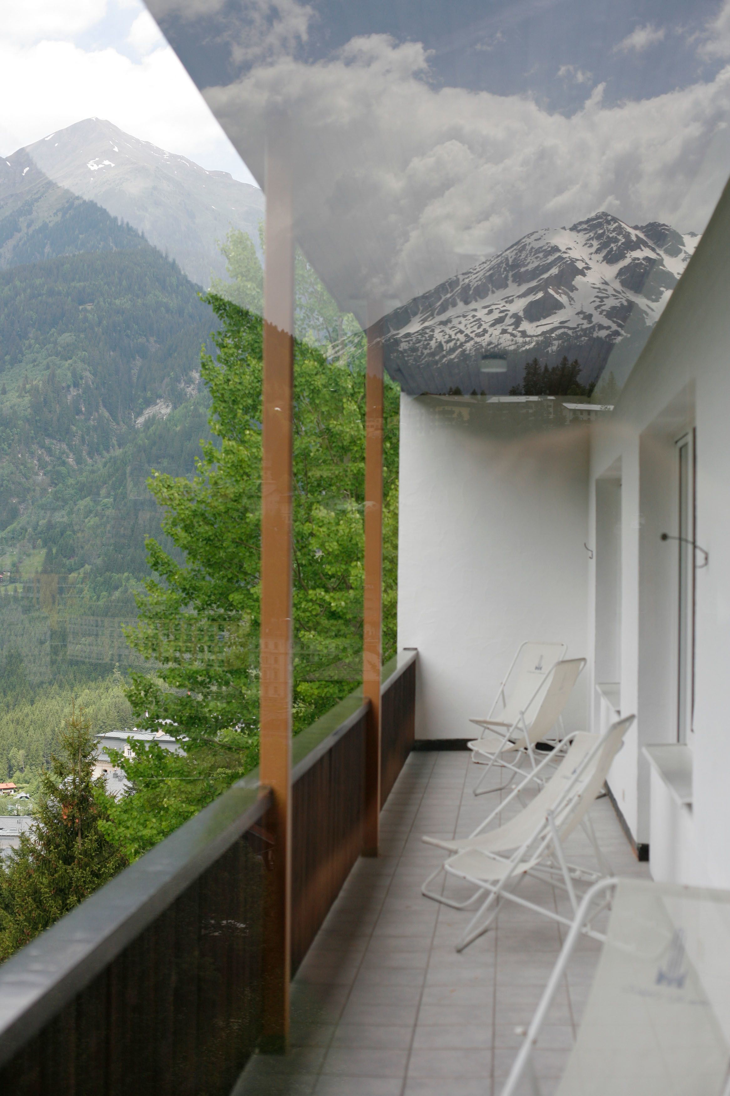Un balcón con vistas a una cordillera y un valle boscoso.