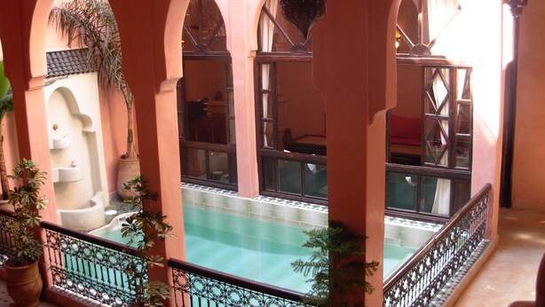 A courtyard with a pool, arched walkways, and potted plants. - Riad Aderbaz (Marrakech)