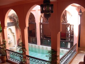 A courtyard with a pool, arched walkways, and potted plants. - Riad Aderbaz (Marrakech)