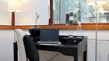 Un espace de bureau moderne comprenant un bureau, une chaise et deux lampes.