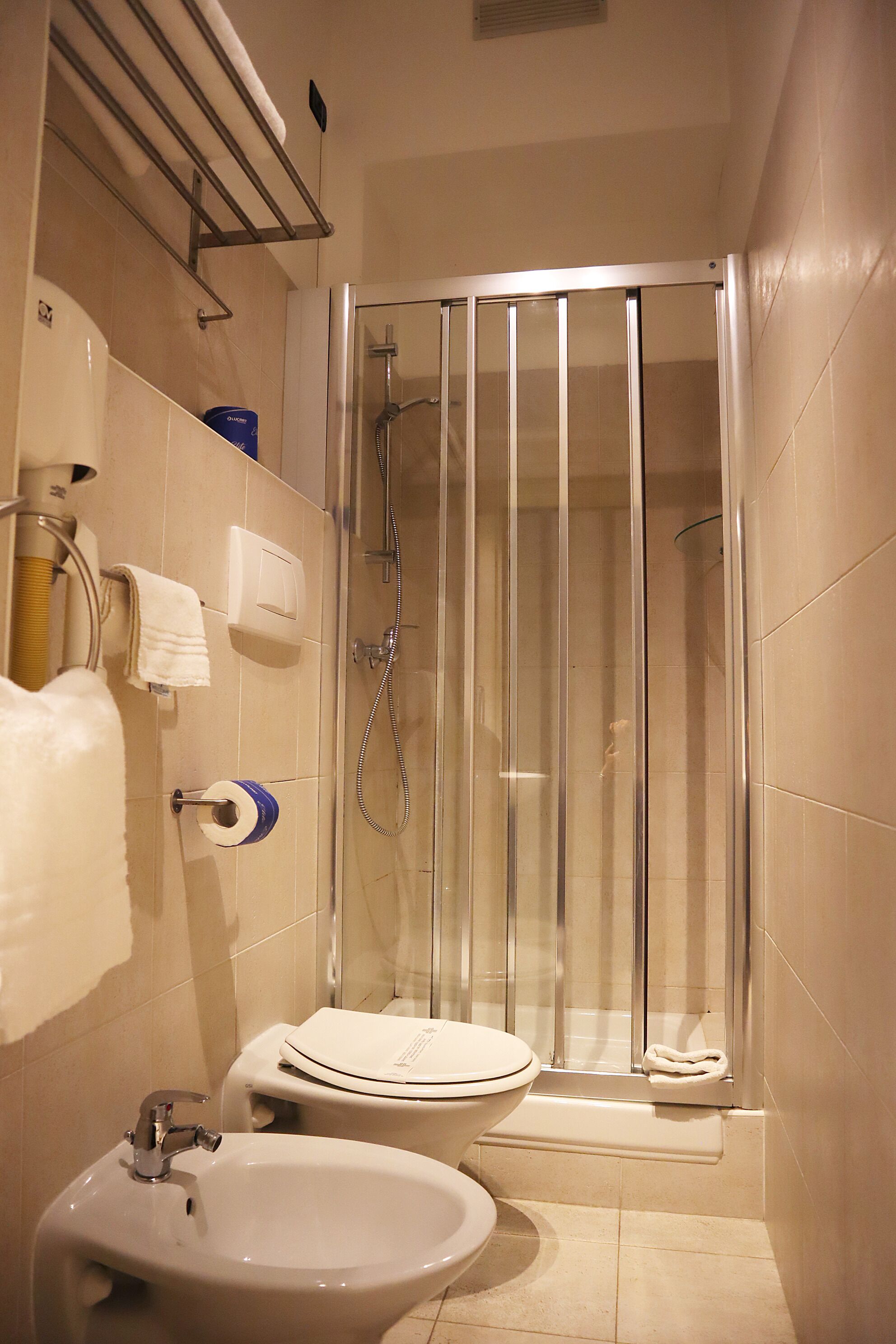 A bathroom with a shower, toilet, and sink.