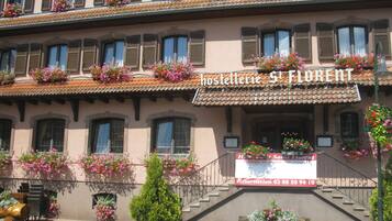 Un edificio con un letrero que dice "Hostel St. Florent" y una escalera que conduce a la entrada.