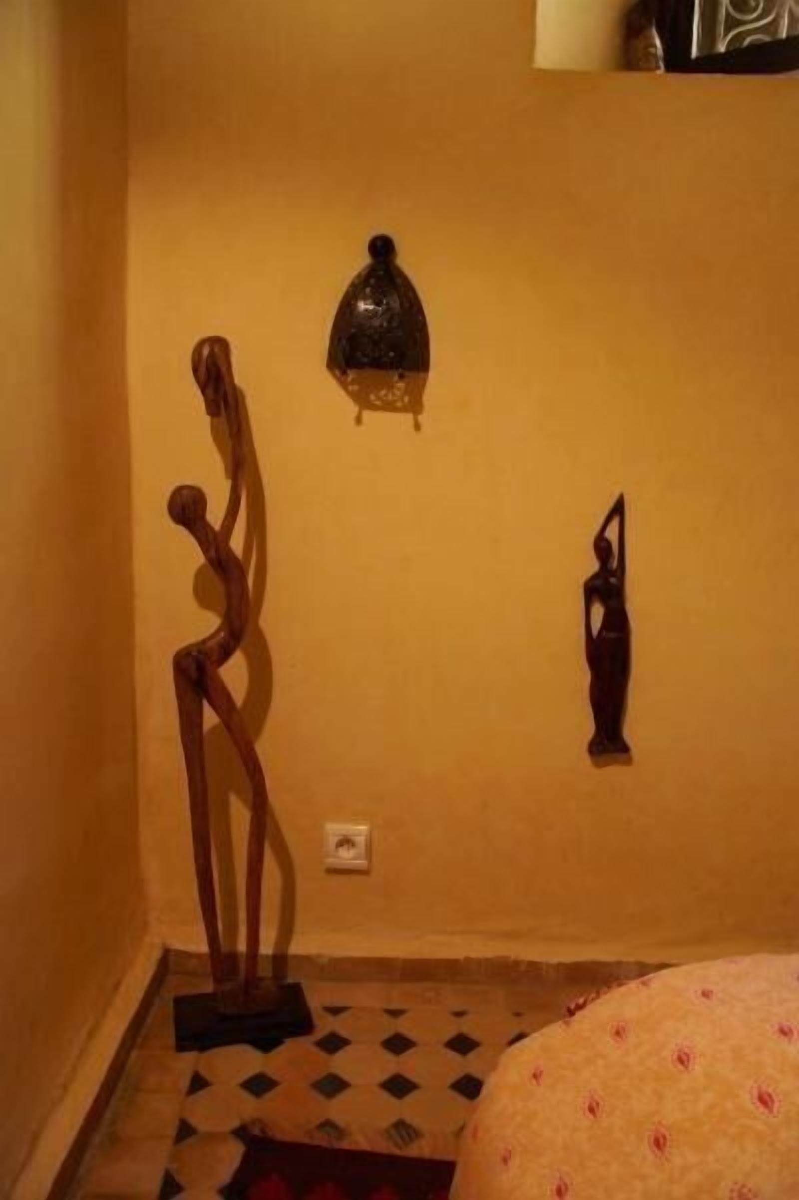 Een kamer met een houten sculptuur, een decoratieve lantaarn en een kamerbreed tapijt.