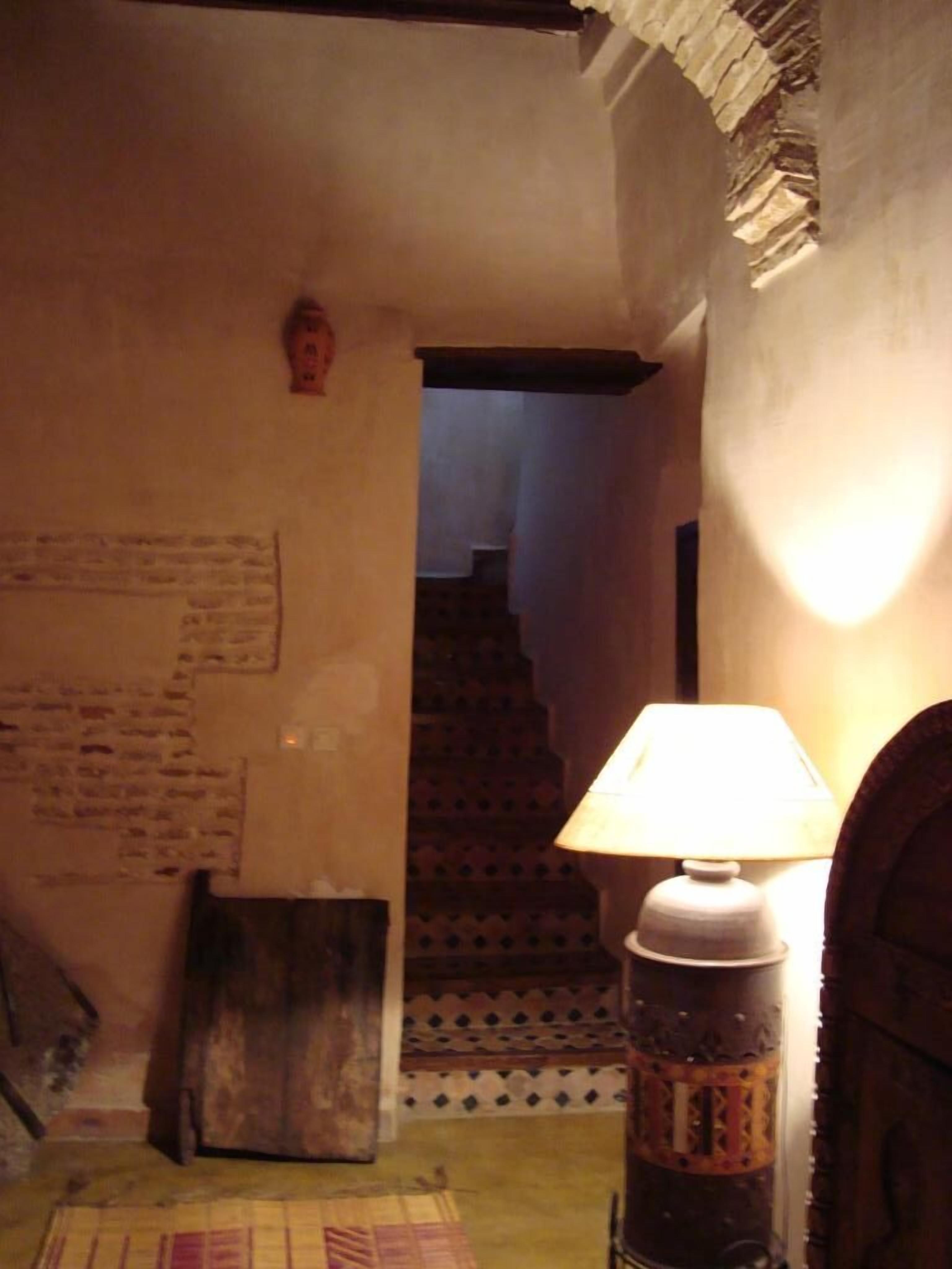 Ein schmaler Flur mit einer Lampe, einer Treppe und einer Wand mit Text.
