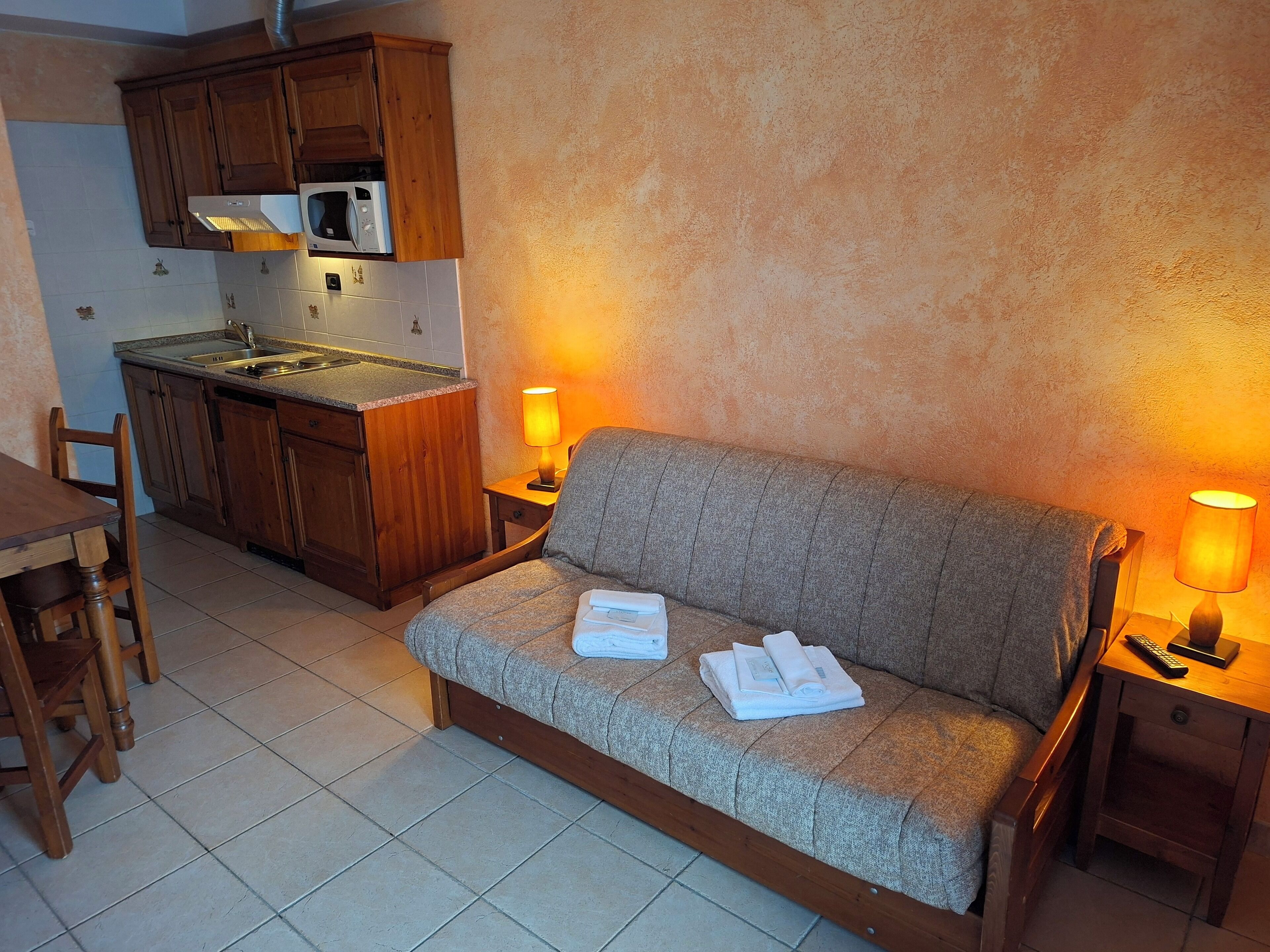 A cozy living area with a sofa, a dining table, and a kitchenette.