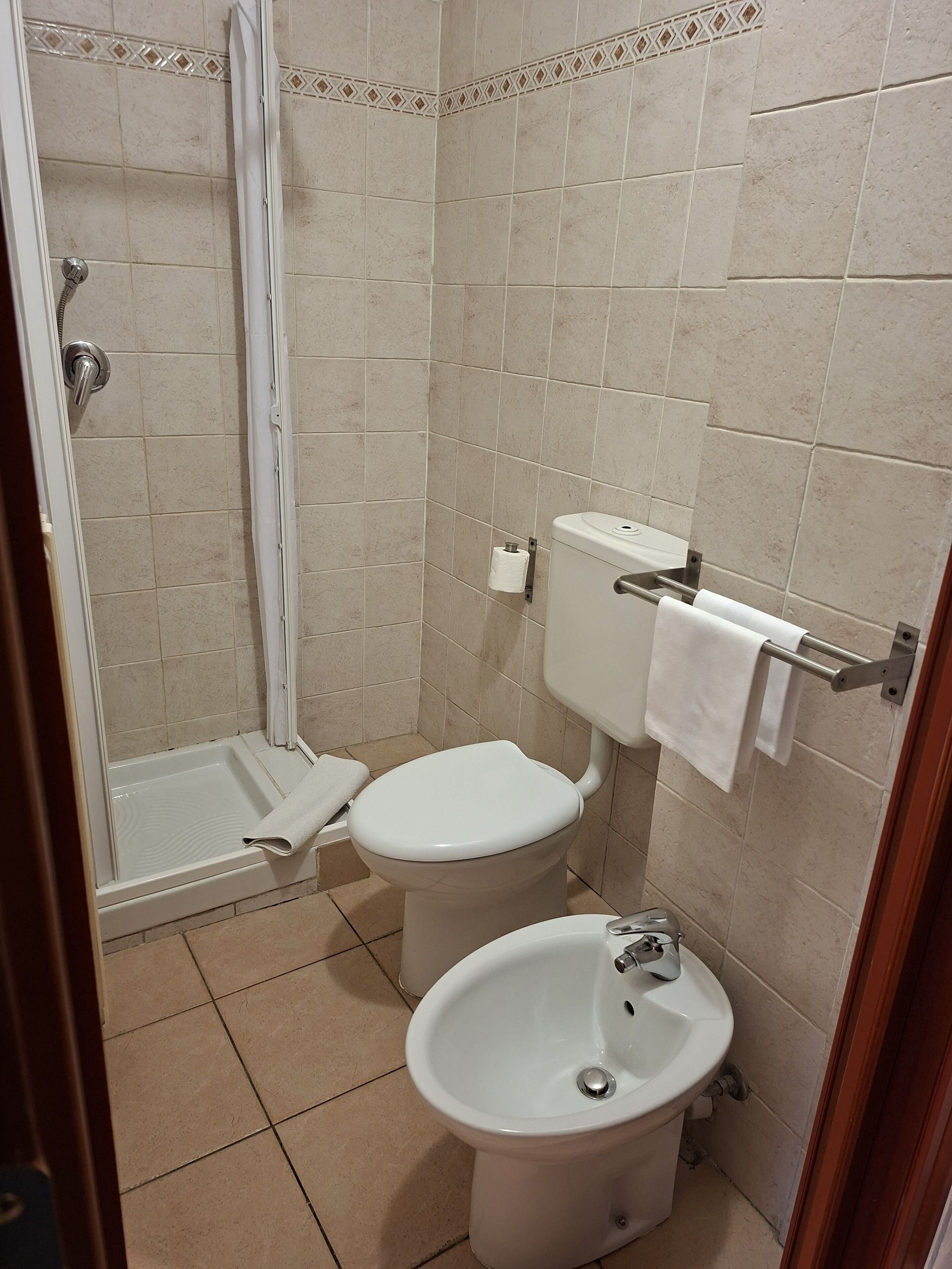 A bathroom with a shower, toilet, and sink.