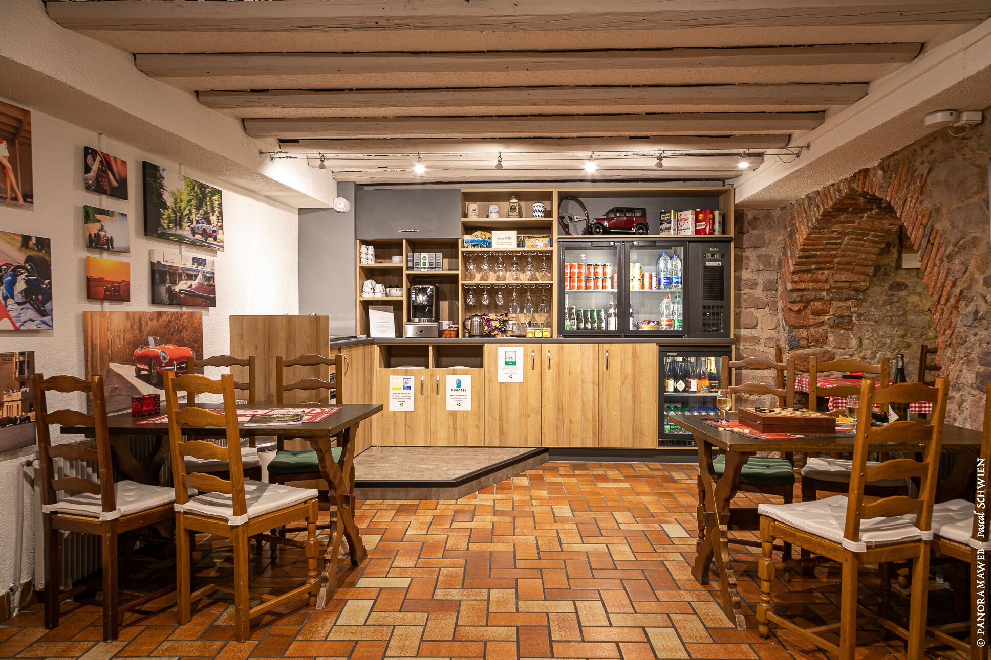 Un espace bar accueillant, avec des meubles en bois, un sol carrelé et un mur en pierre.