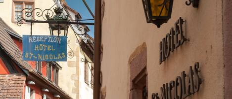 A hotel sign with the name "HOTEL ST-NICOLAS" and a reception sign above it.