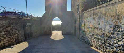 A stone pathway leading to a historic building with a large archway.