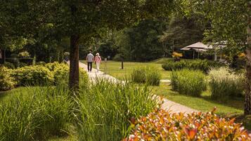 Un sentier traversant un jardin verdoyant, avec un kiosque.