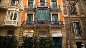 Un edificio de varios pisos con balcones ornamentados y ventanas grandes.