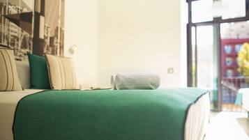 Un dormitorio con cama, almohadas, ventana y vistas al exterior.