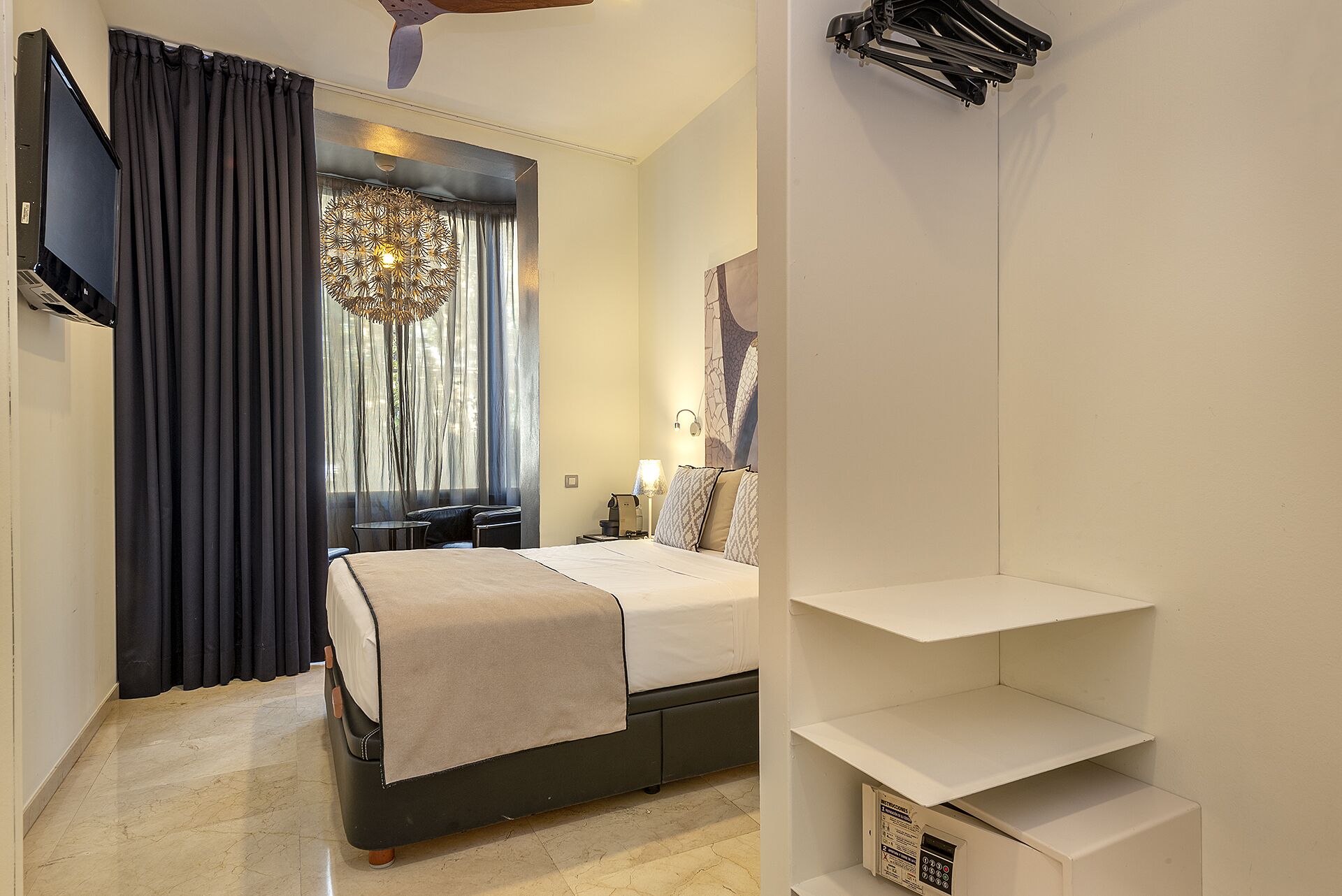 A hotel room with a bed, a TV, a desk, and a chair.