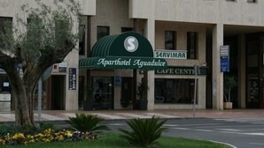 The exterior of Aparthotel Aguadulce with a green awning and a sign for Servimar Cafe Center. - Aguadulce (Roquetas de Mar)