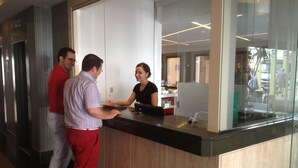 A reception area with a counter, a glass partition, and a view of the street outside. - Aguadulce (Roquetas de Mar)