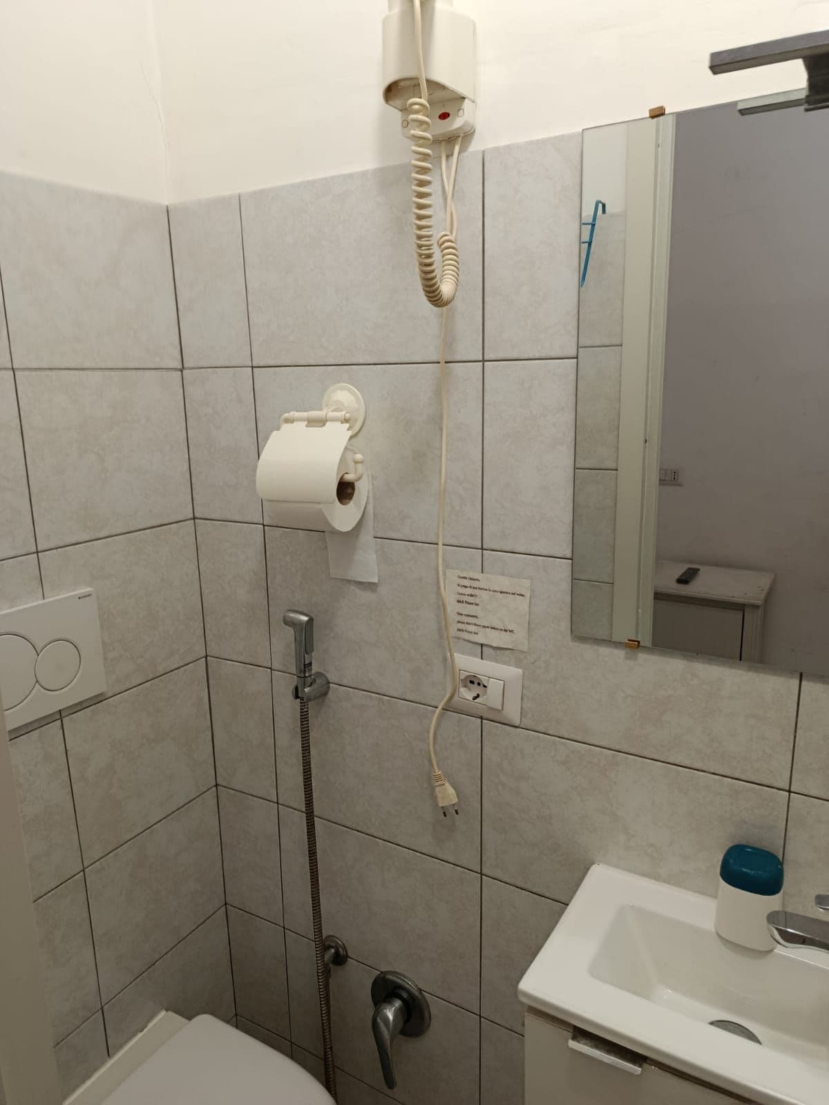 A bathroom with a shower, a toilet, a sink, and a mirror.