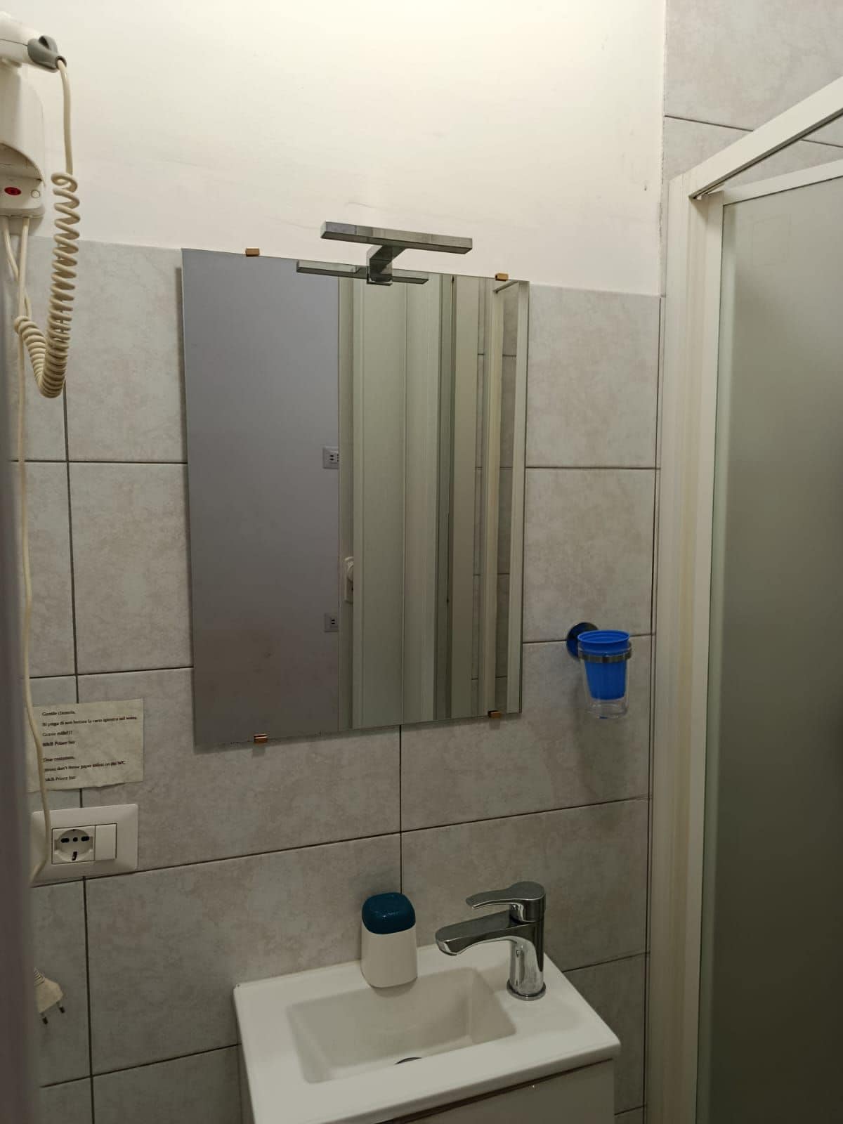 Une salle de bain avec un miroir, un lavabo et une douche.