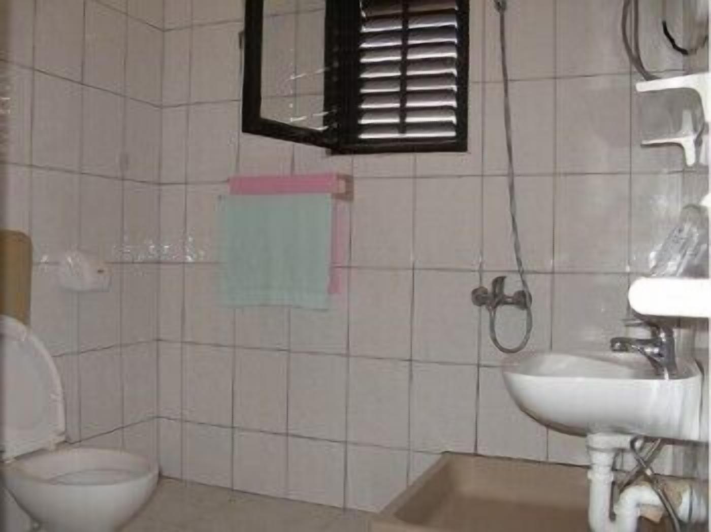 A bathroom with a toilet, sink, and shower area.