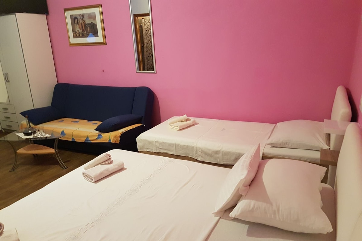 Una habitación con dos camas, un sofá y una mesita.