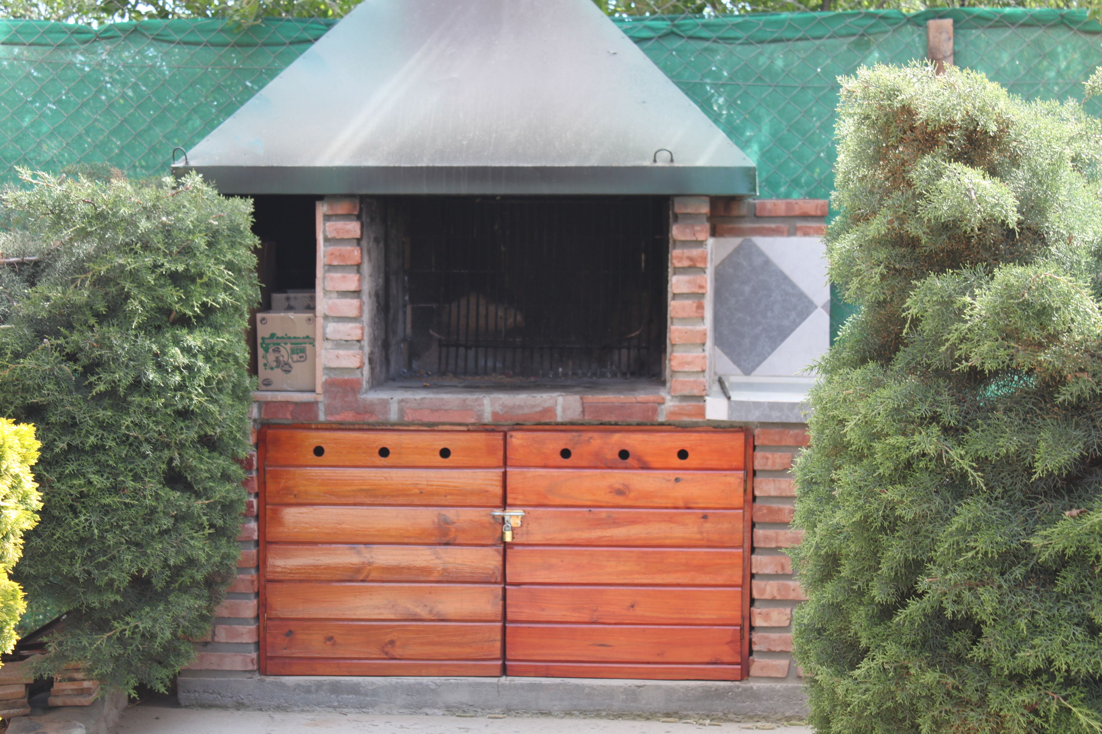Un edificio de ladrillo con techo verde y puerta de garaje de madera.