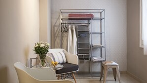 A compact bathroom with a freestanding bathtub, a vanity with a mirror, and a small table with a vase of flowers. - Ainb B&B Eixample Muntaner (Barcelona)