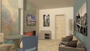 Una sala moderna con chimenea, una mesa de comedor y un sofá. Hay cuadros en las paredes y una puerta al fondo.