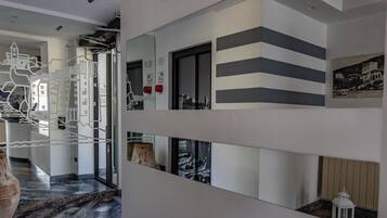 A modern interior with a hallway leading to a room with a view of a cityscape.