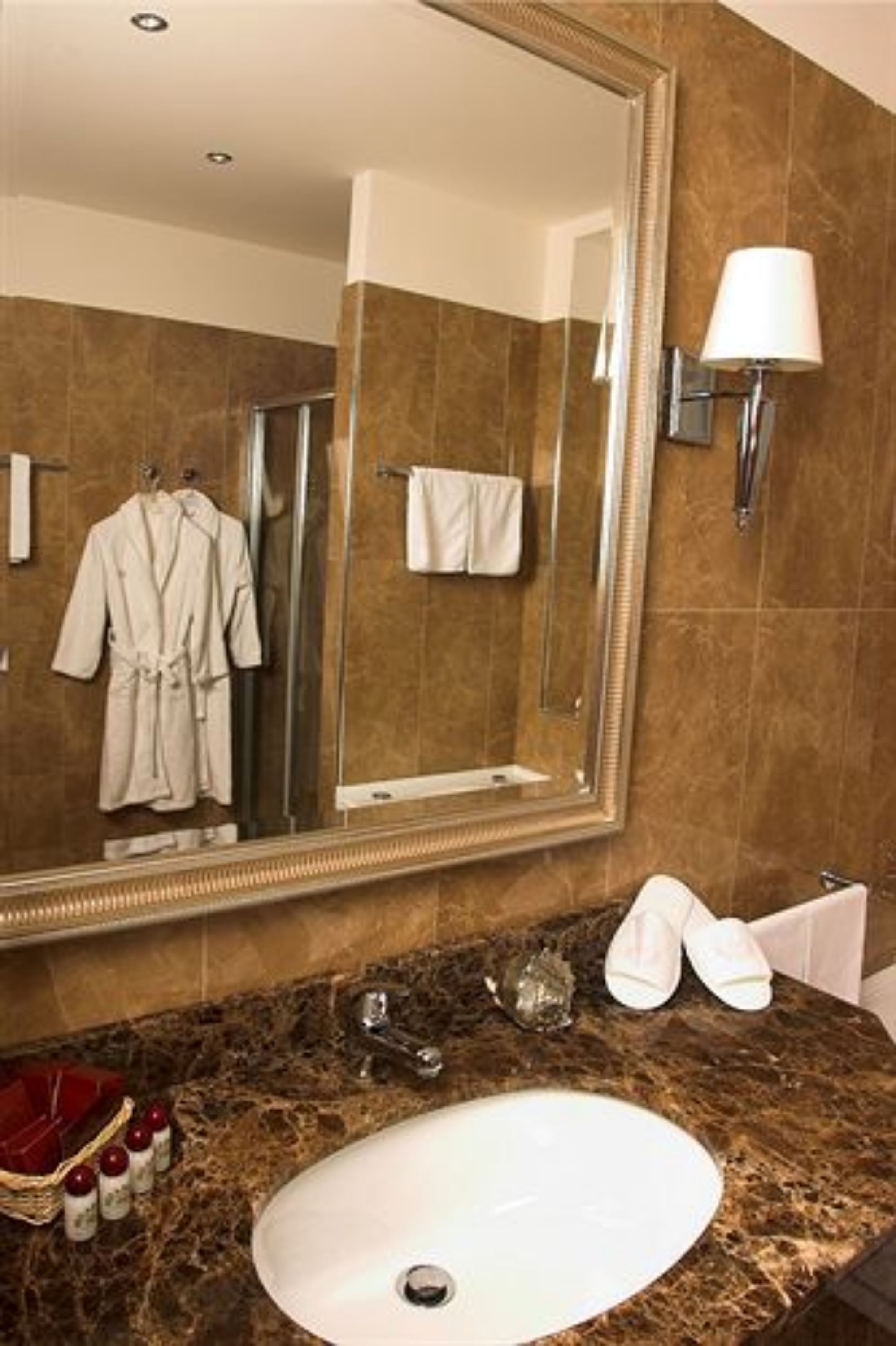 Un baño con un espejo grande, un lavabo y un perchero para toallas.
