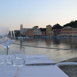 Enjoy a scenic waterfront dining experience with a view of boats and historic buildings.