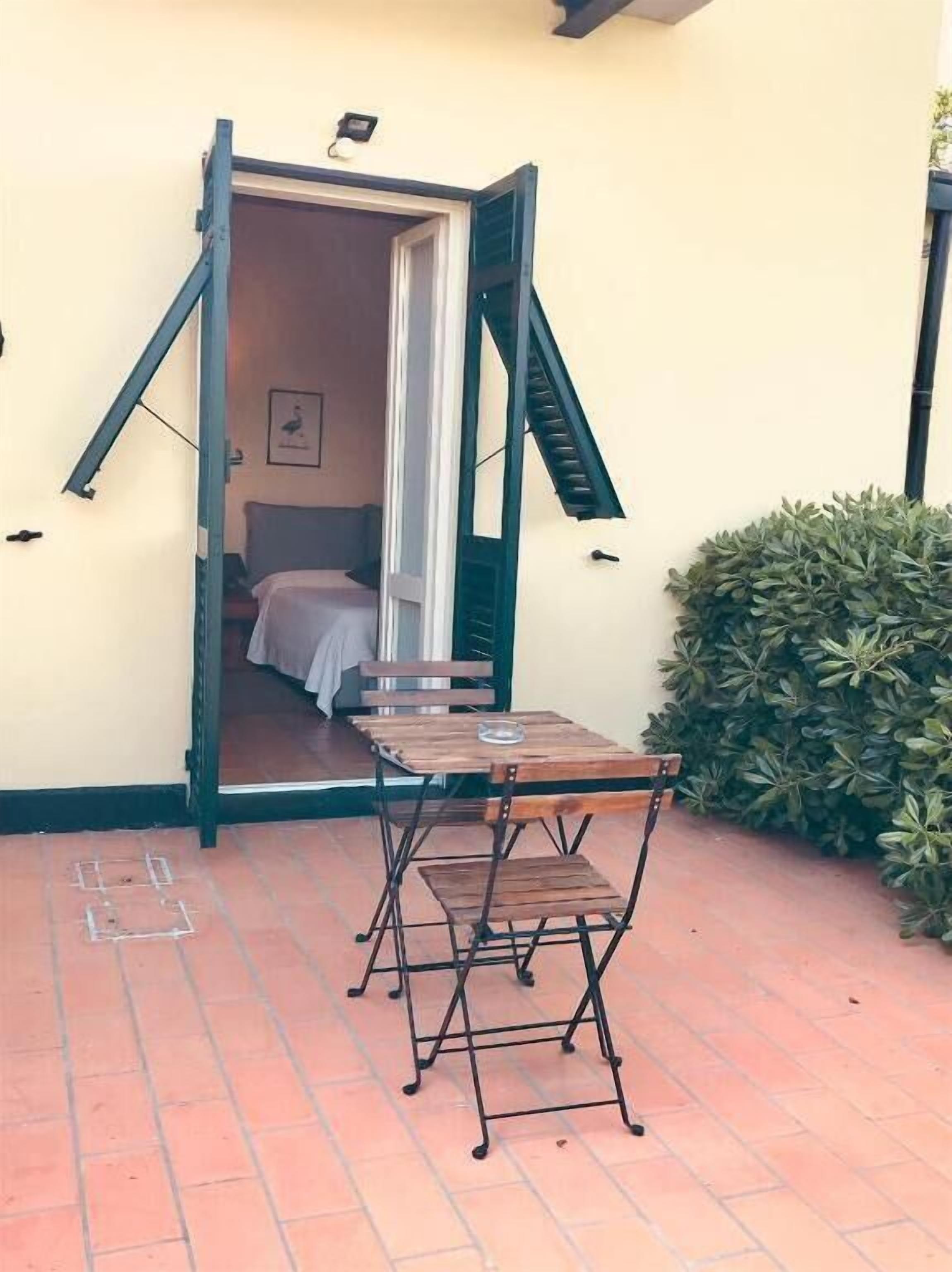 An open doorway leading to a bedroom with a bed and a chair.
