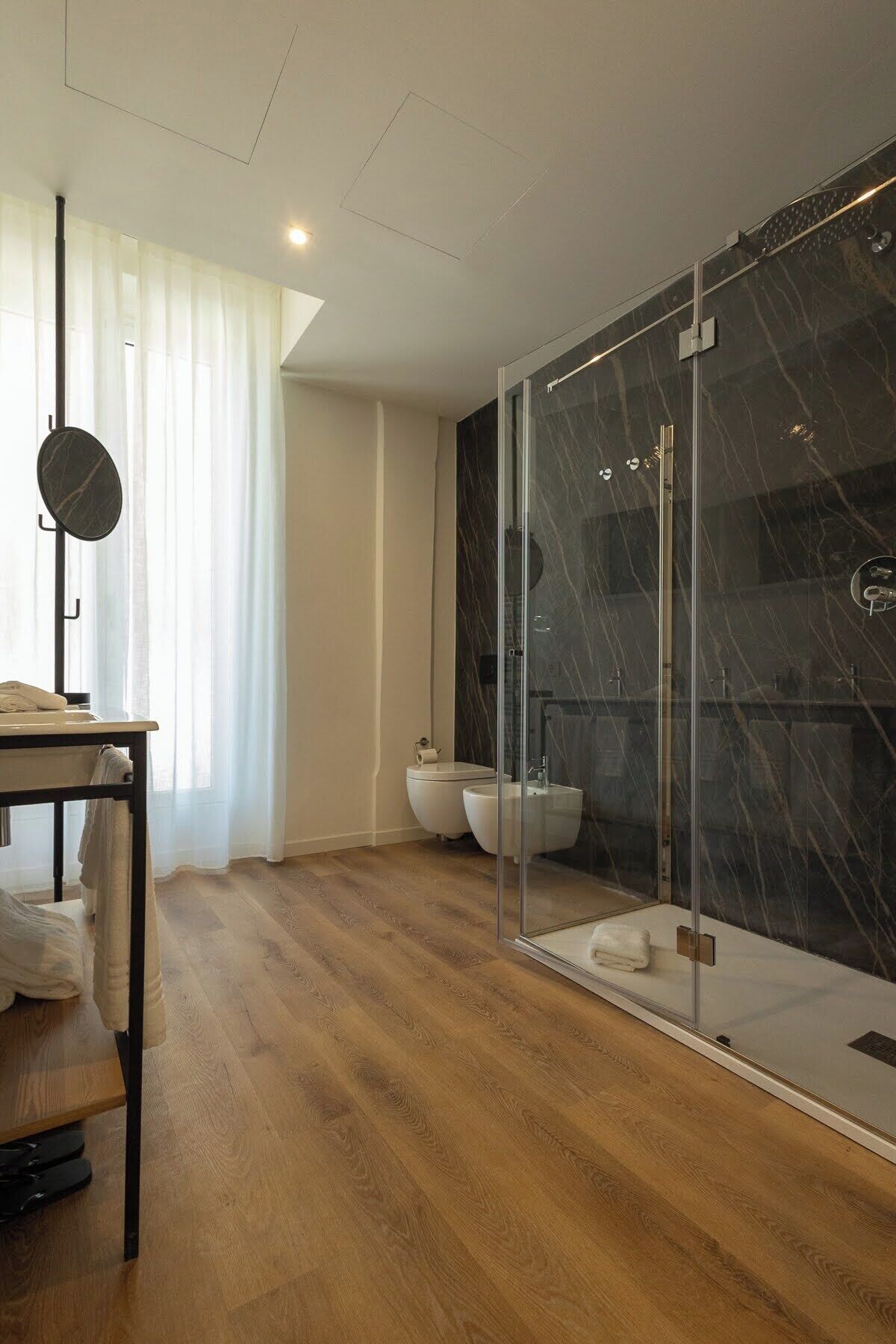 Un baño moderno con cabina de ducha de vidrio, inodoro y bidé.