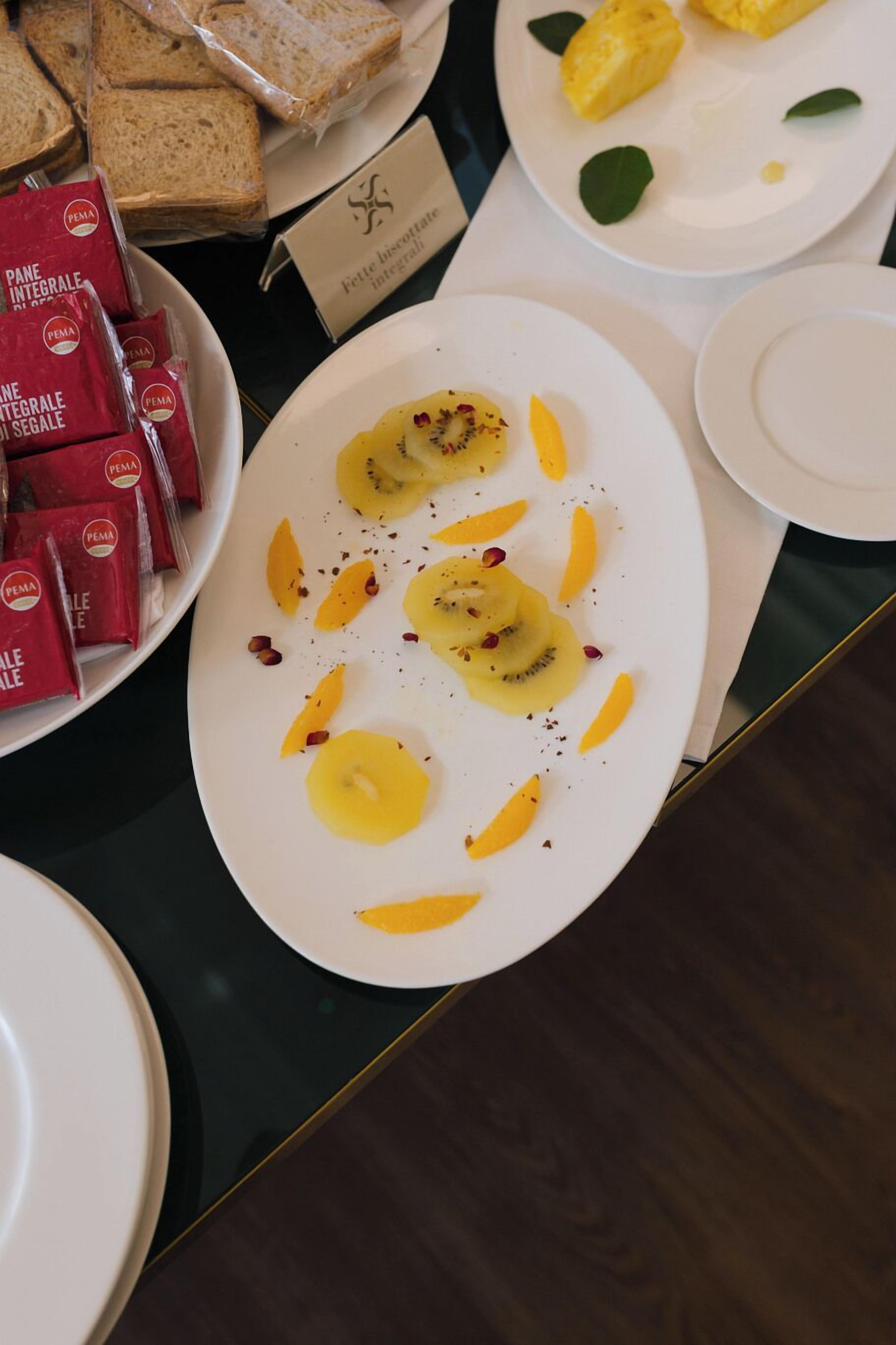 Monipuolinen aamiaisbuffet, jossa on tarjolla erilaisia ruokia ja leipää.