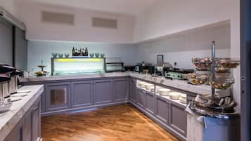 Una cocina moderna con armarios grises, encimera de mármol y suelo de madera en espiga.