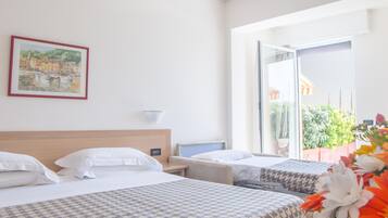 A hotel room with two beds, a bedside table, a nightstand, a painting, and a view of the outdoors.