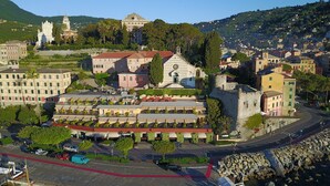 A coastal town with a prominent church, a castle-like structure, and a row of colorful buildings. - Hotel Laurin (Santa Margherita Ligure)