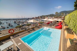 Una piscina al aire libre de temporada, sombrillas