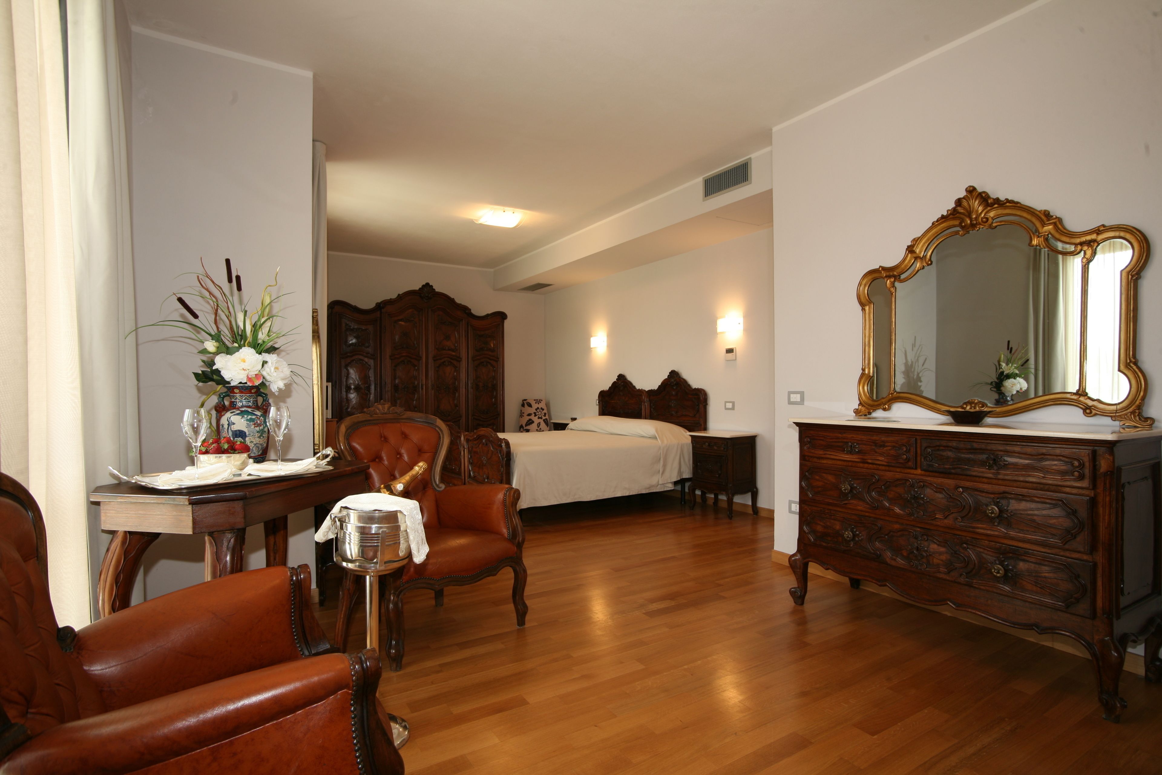 Un dormitorio con un aparador de madera, un espejo grande, una cama y una silla.