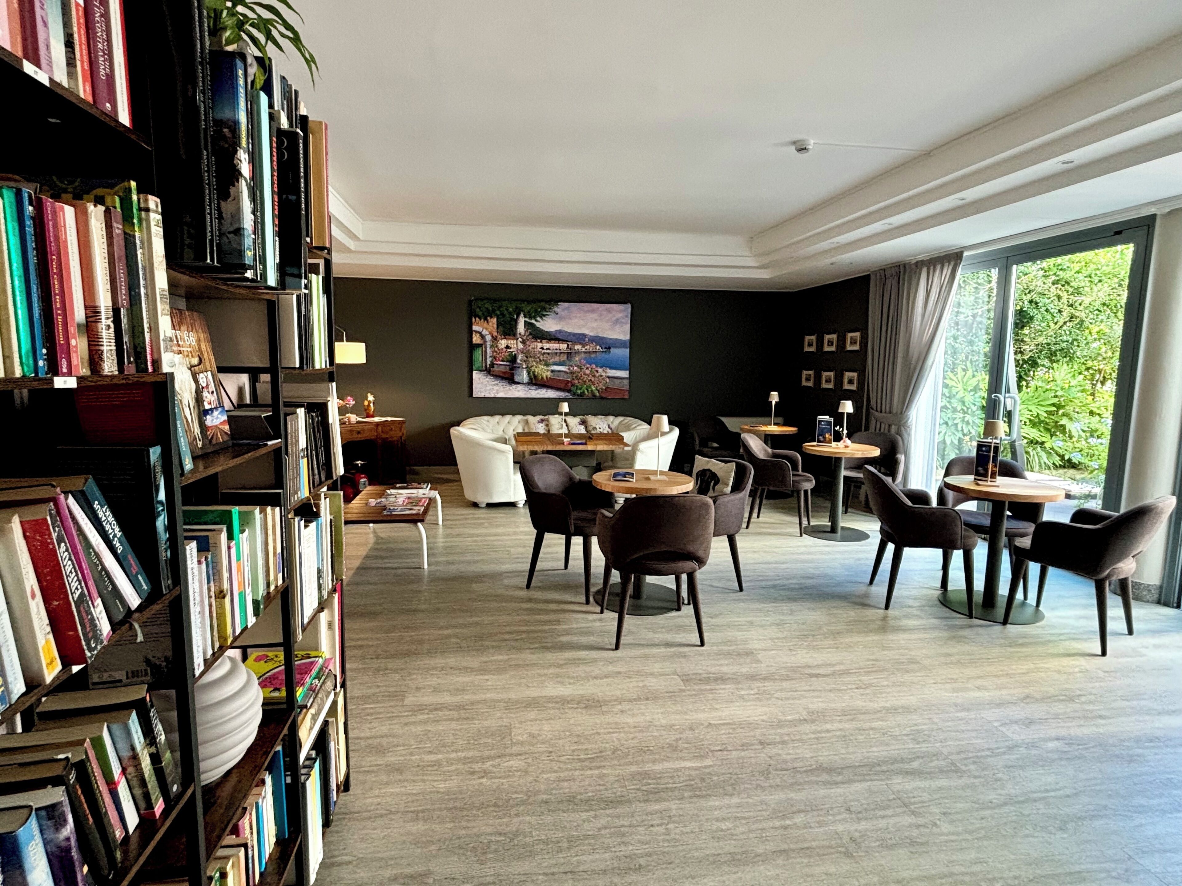 Un vaste espace de vie comprenant une bibliothèque, un canapé et plusieurs coins salon.