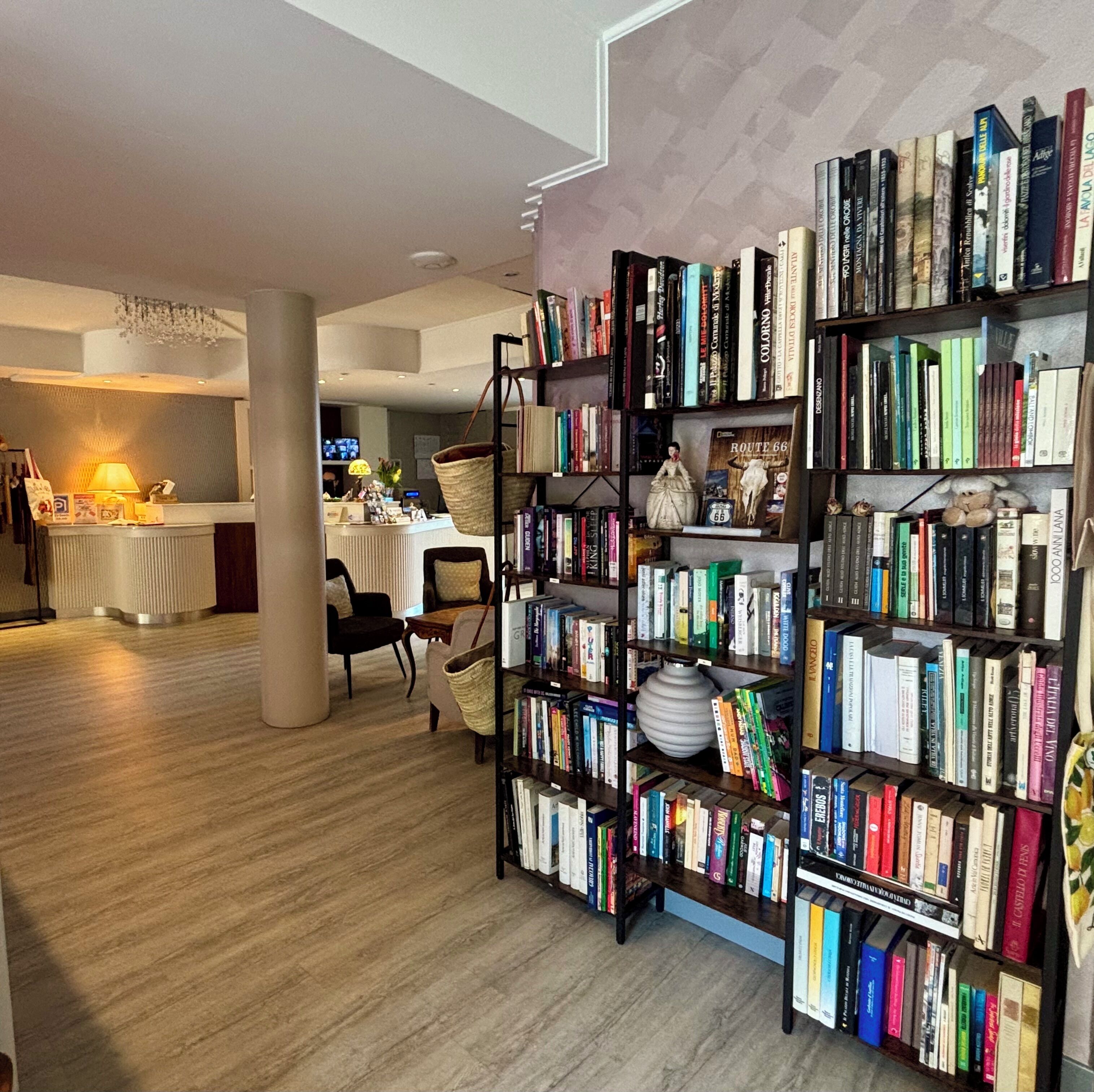 Et bibliotek med reoler, en receptionsdisk og et spiseområde.