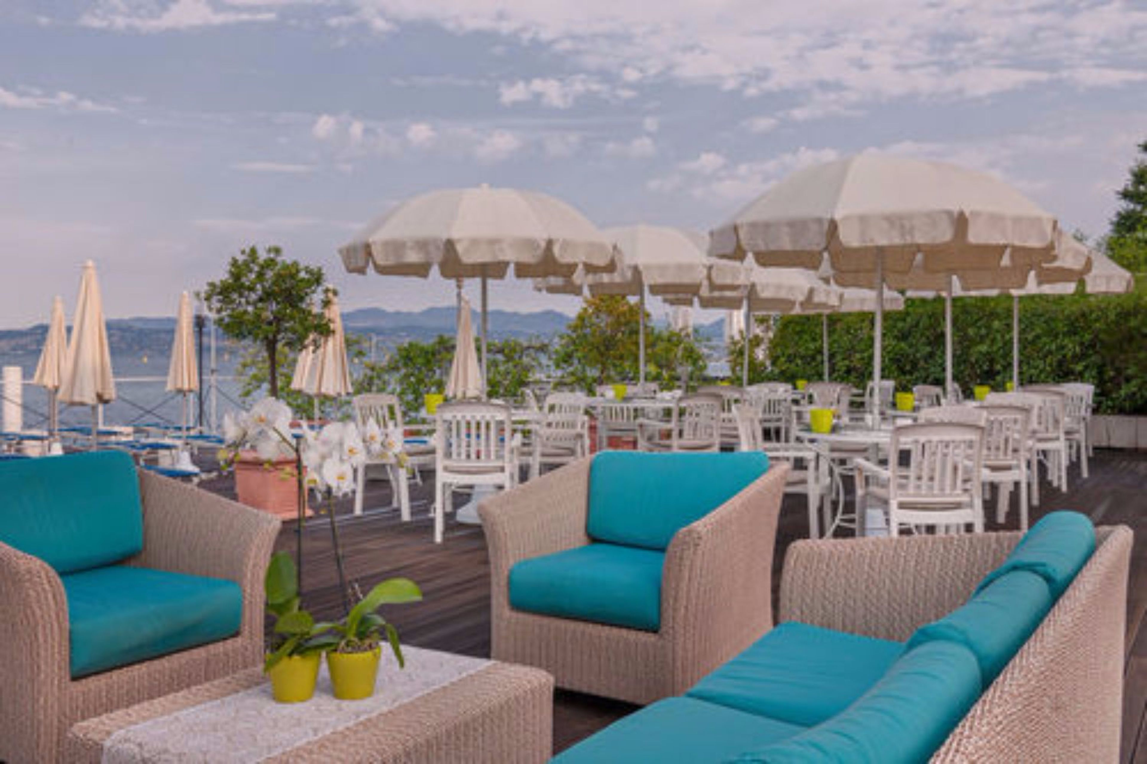 Een terras met rieten meubilair en witte parasols.